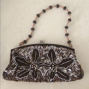 Woman’s beaded clutch in brown and gold color.